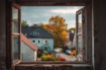 Vue par la fenêtre d'une maison à rénover selon les standards urbains